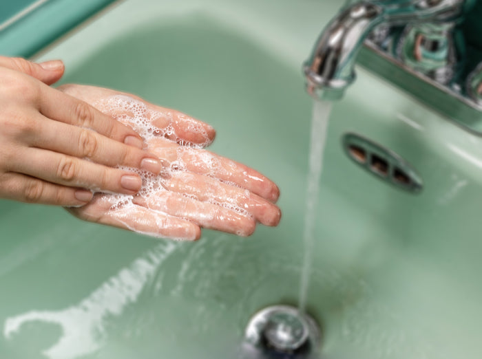 a person washes their hands using soap