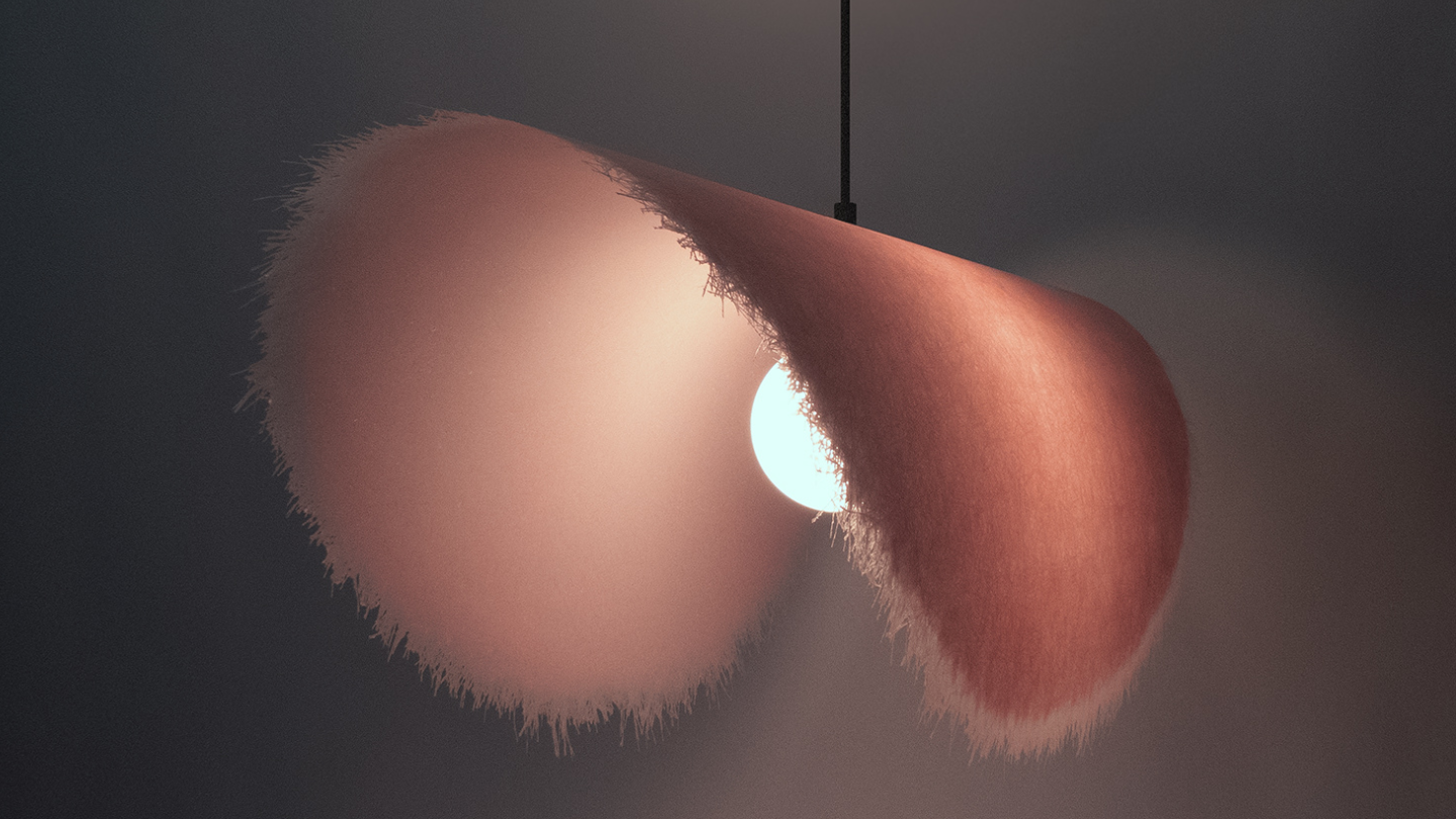 Fuzzy modern pink lamp with a light bulb inside on a dark background