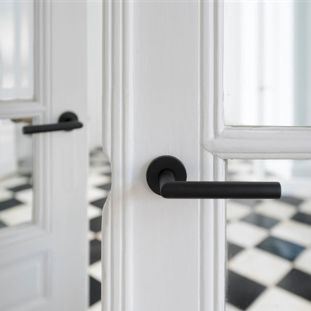 A close up of a Formani BASICS LBII-19 Door Lever on a door.