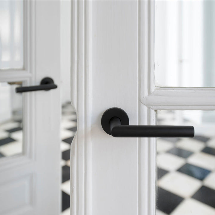 A close up of a Formani BASICS LBII-19 Door Lever on a door.