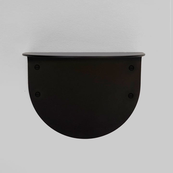 A black CSSN BENDE Shelf Ledge mounted to the side of a wall.