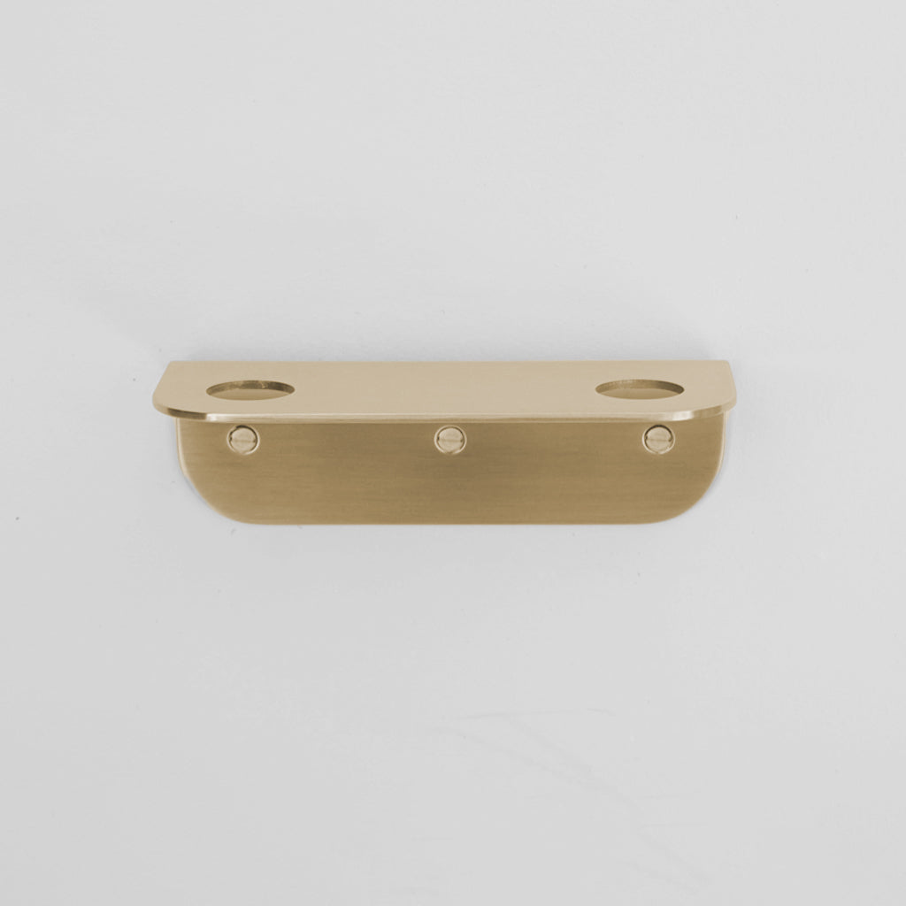 Bende Double Soap Holder in satin brass mounted on white wall with 3 slot head screws