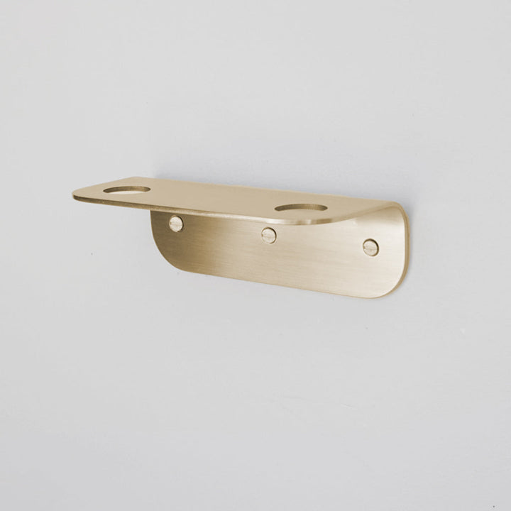 Bende Double Soap Holder in Satin Brass mounted on white wall with 3 slot head screws