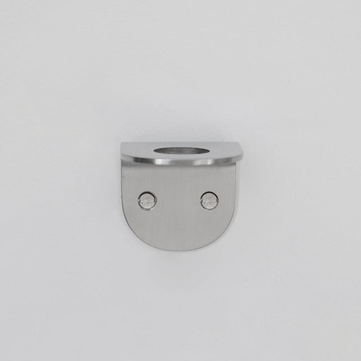A CSSN BENDE Soap Holder Bracket Single with two holes in the middle.