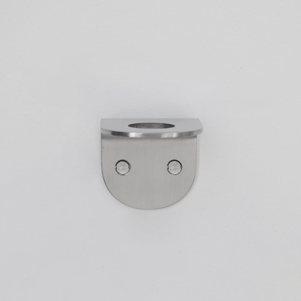 A CSSN BENDE Soap Holder Bracket Single with two holes in the middle.