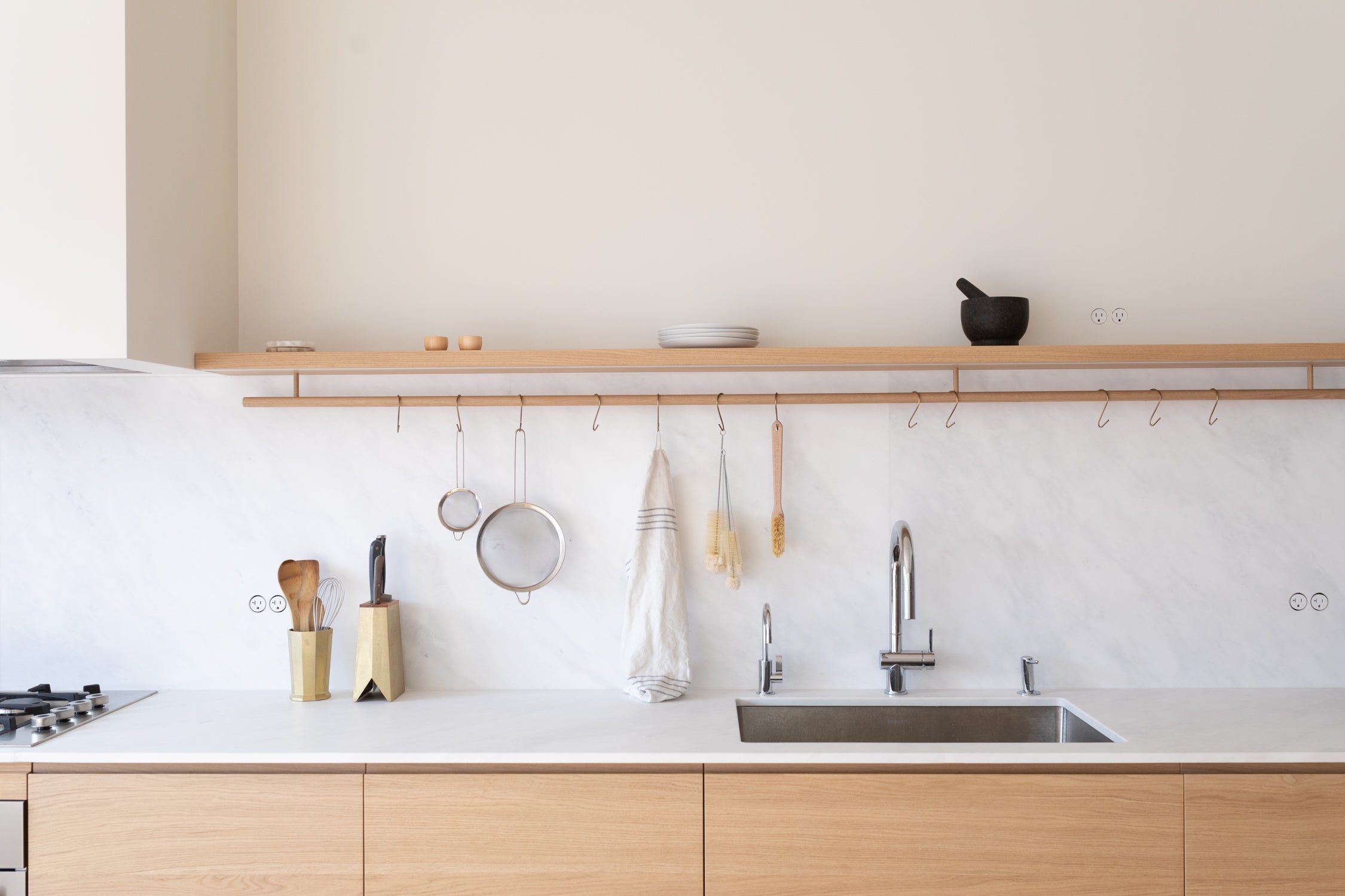 Modern Nordic kitchen with white marble backsplash, Bocci 22 flush outlets, oak cabinetry, and minimalist Japanese brass kitchen tools—elevated hardware and refined interiors.