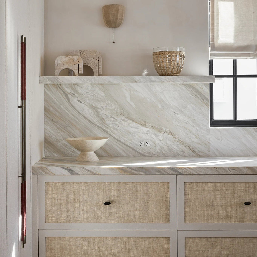 Modern kitchen with marble backsplash and wooden cane cabinets. Flush Bocci outlets in marble backsplash.