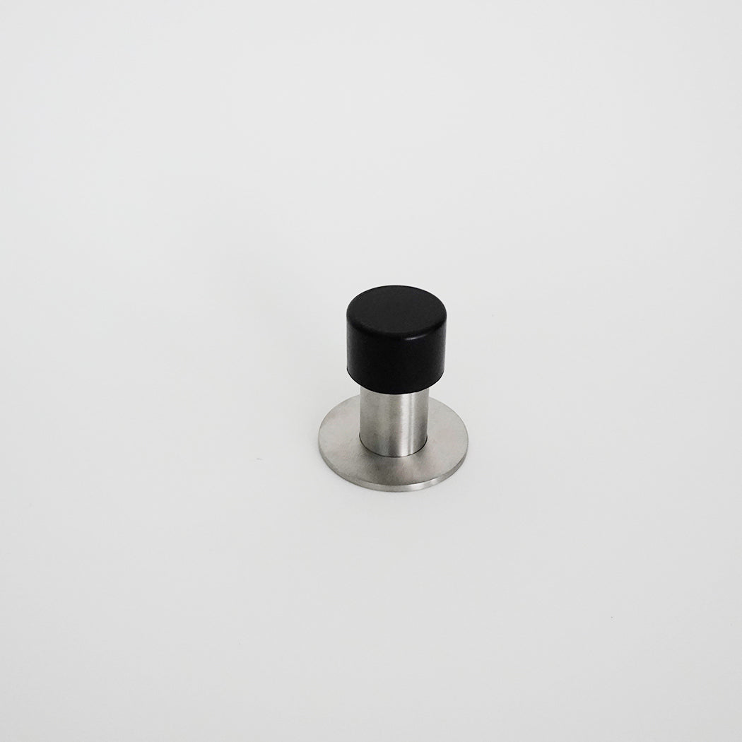 An AHI Capped Door Stop with a black and silver knob on a white surface.