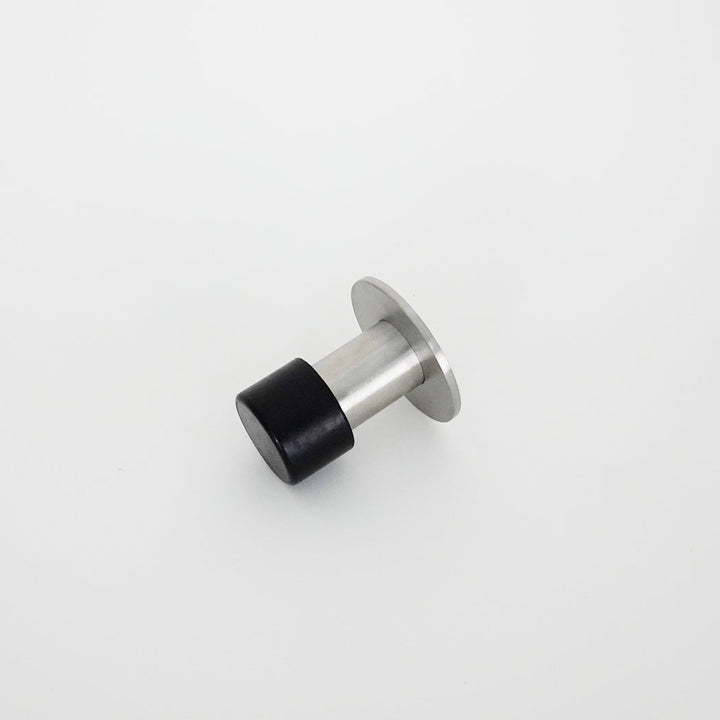 A close up of an AHI Capped Door Stop on a white surface.