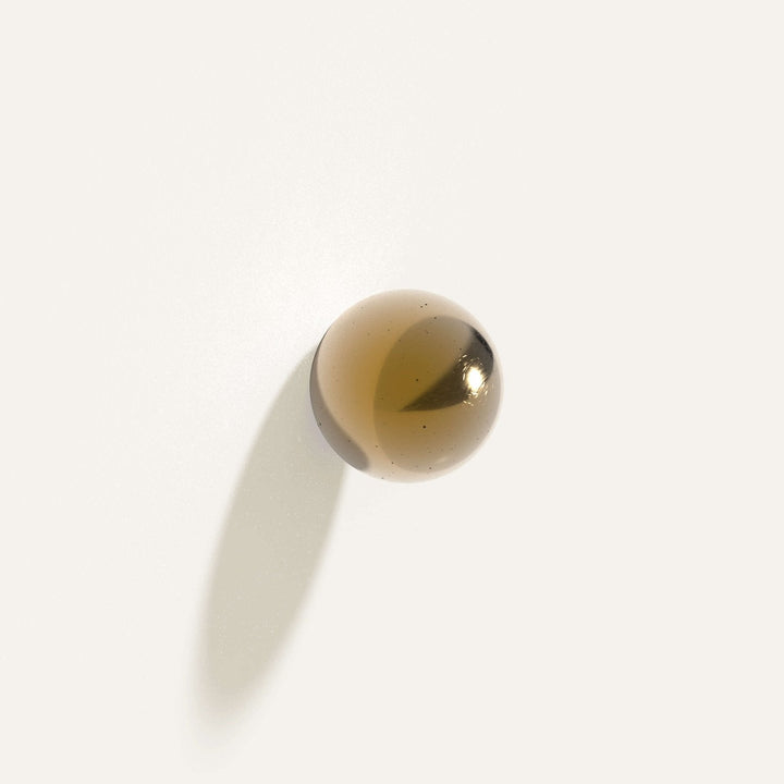 Cercle Knob Large in polished bronze installed on a white wall.