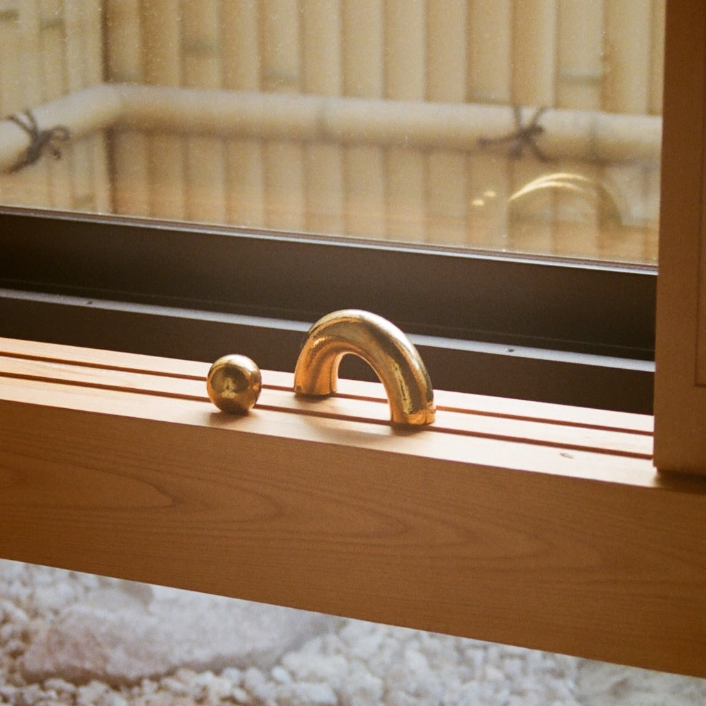 Brass Maha Alavi Cercle pull on a mirrored shelf.