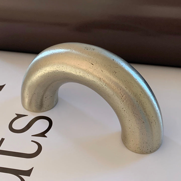 solid cast natural and white brass and bronze curved cabinet hardware handle by Maha Alavi