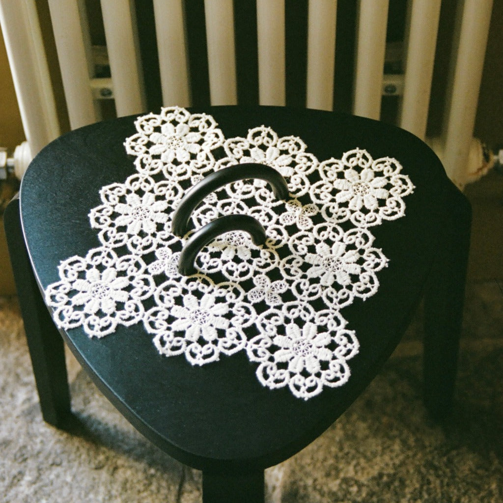 Dark bronze Maha Alavi Cercle thin pulls styled on a lace doily.