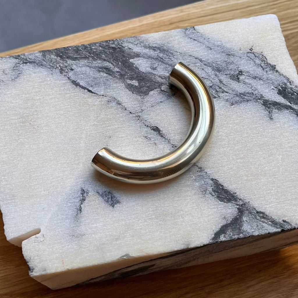 Brass Maha Alavi Cercle thin long pull on marble.