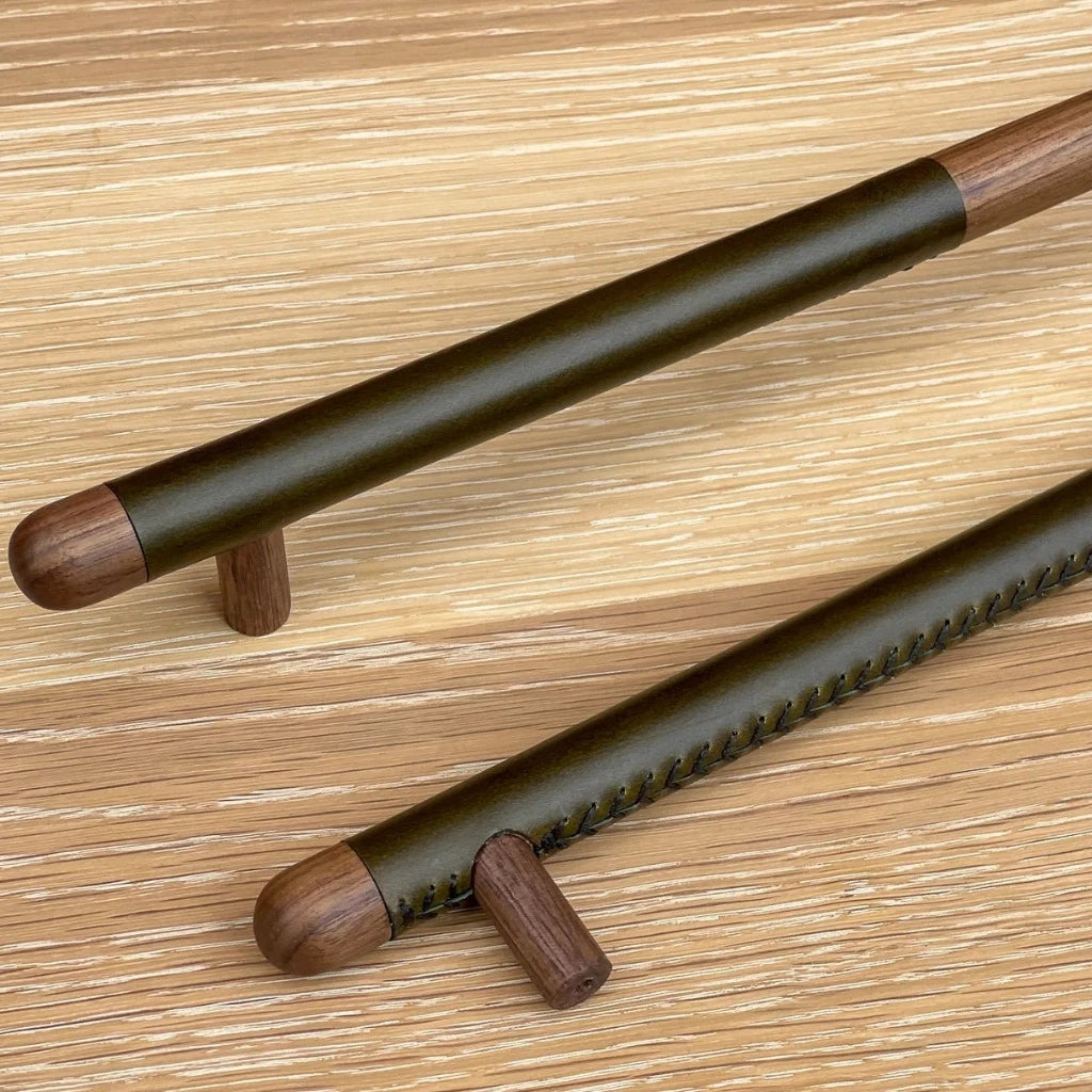 A wood and green leather Chapman & Bose appliance bar pull.