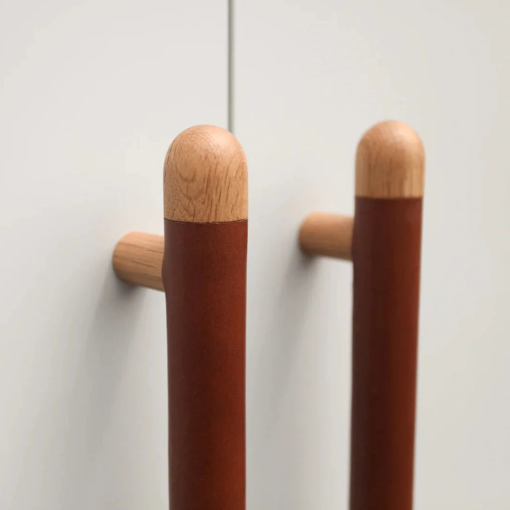 A wood and brown leather Chapman & Bose appliance bar pull.
