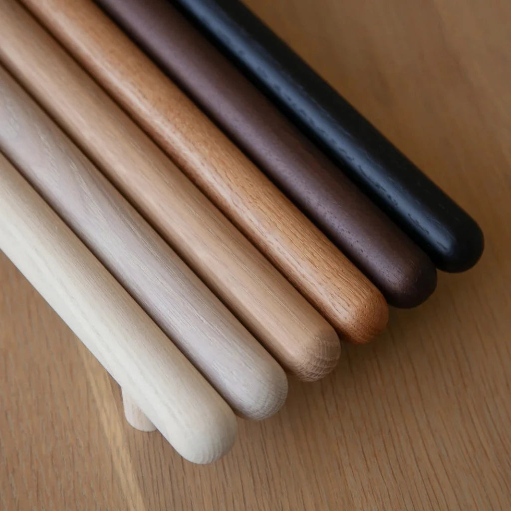 Chapman & Bose wood bar pulls stacked in mixed wood tones.