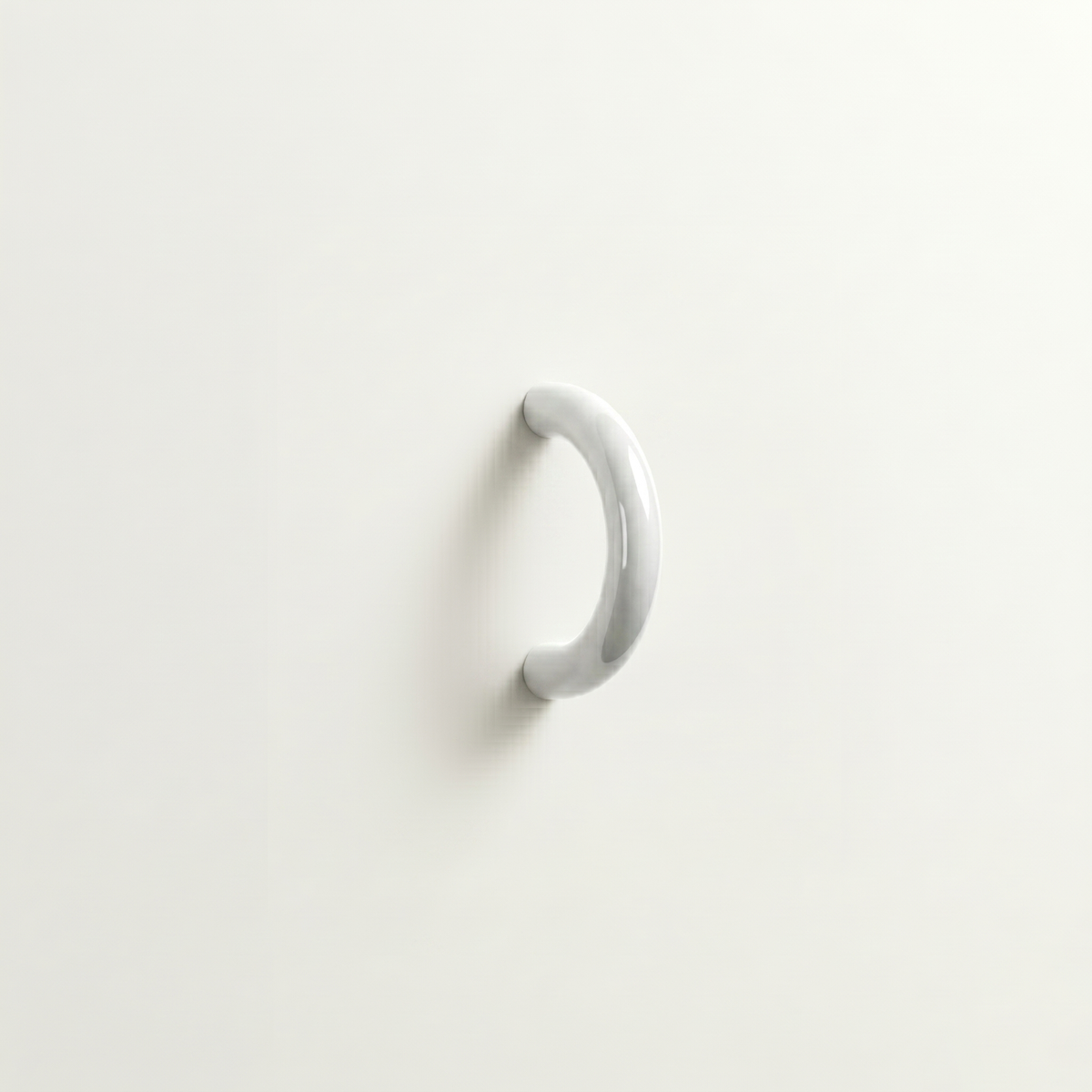Polished chrome Charlie Arc pull, a small half-round arc handle, mounted on a white surface.