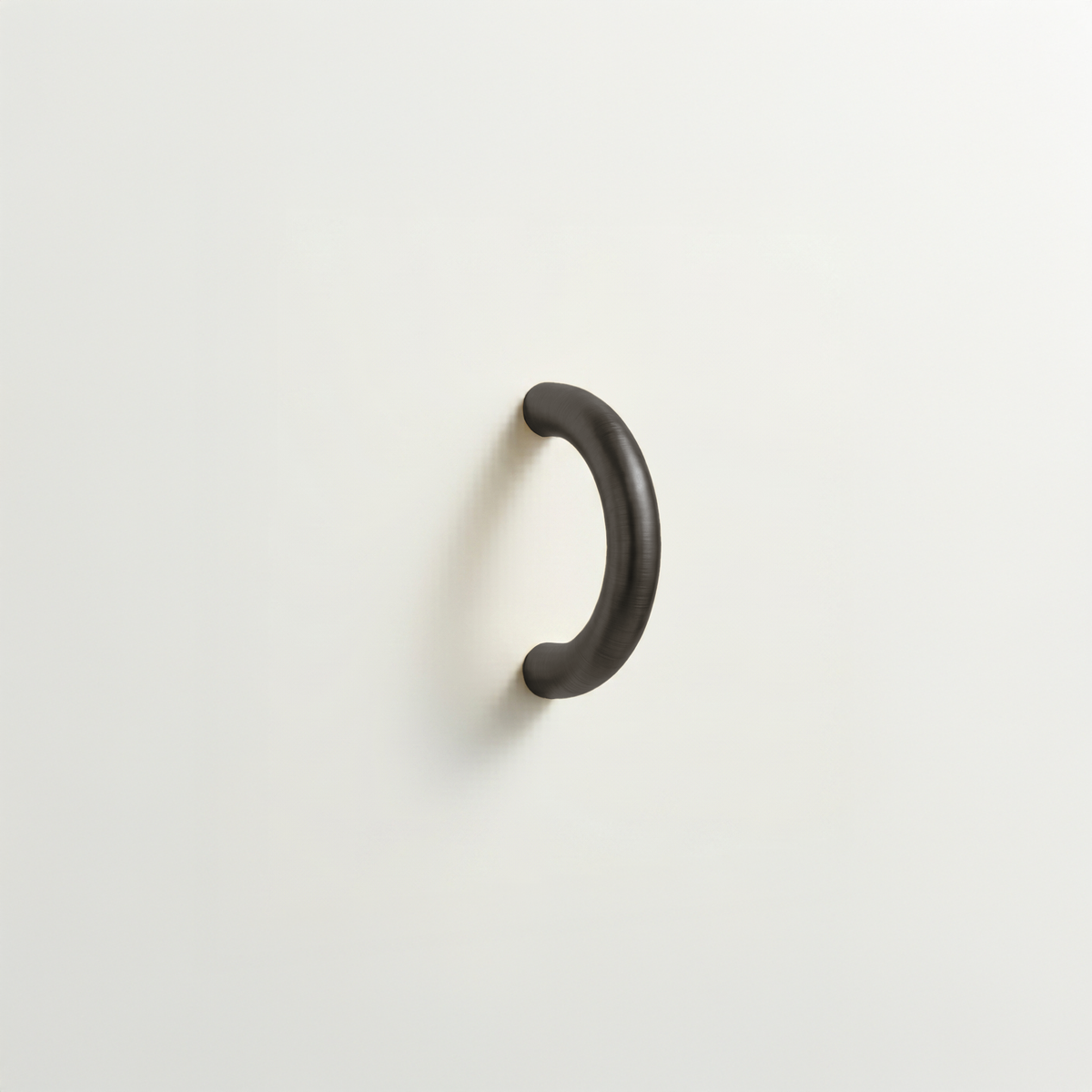 Dark bronze Charlie Arc pull, a small half-round arc handle, mounted on a white surface.