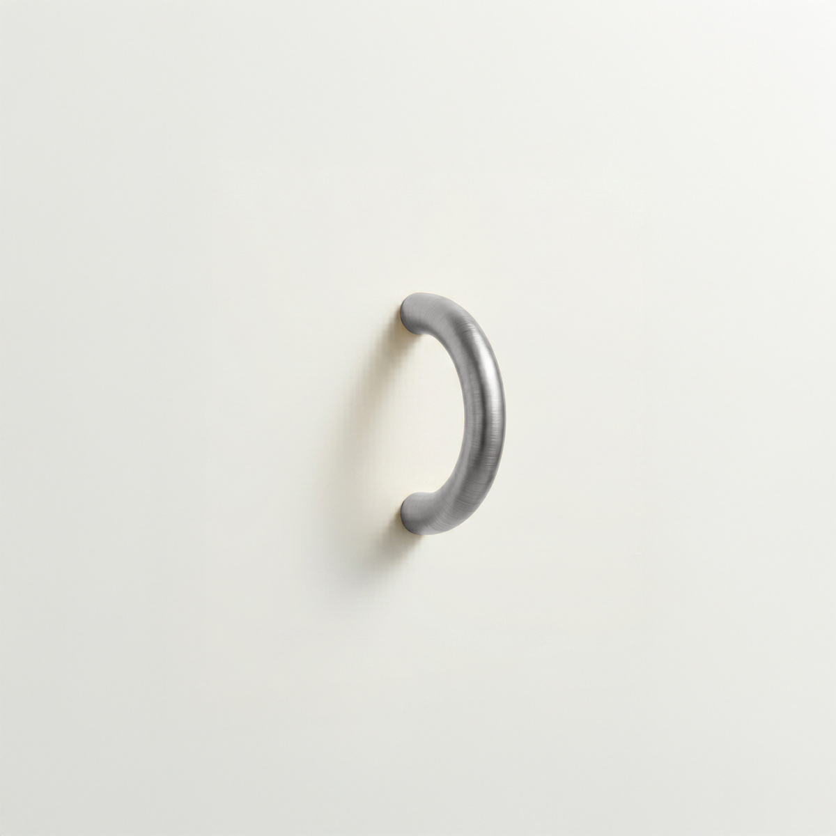 Polished chrome Charlie Arc pull, a small half-round arc handle, mounted on a white surface.