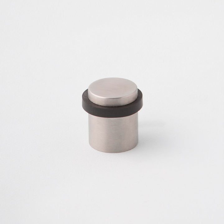 Stainless Steel floor mounted doorstop with black rubber dampener.Charlie Door Stop Stainless Steel. Made in Toronto.