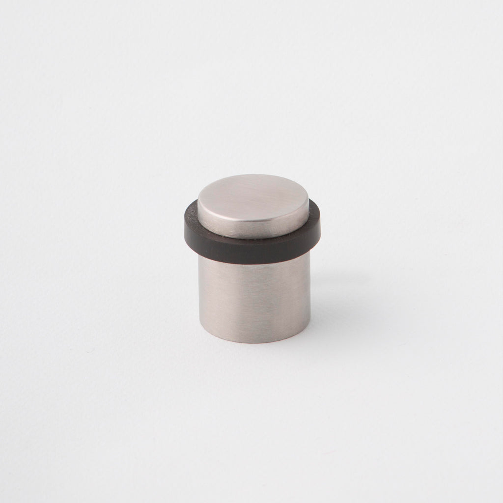 Stainless Steel floor mounted doorstop with black rubber dampener.Charlie Door Stop Stainless Steel. Made in Toronto.