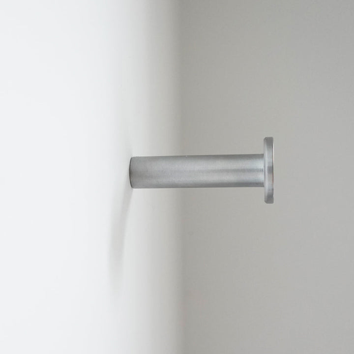 A close up of a CBH Charlie Nail Hook on a white wall.