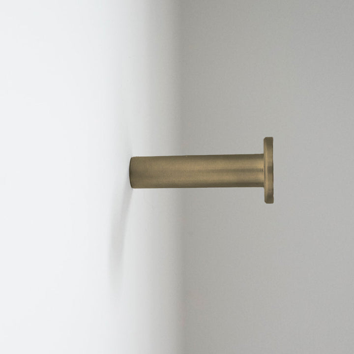 a close up of a CBH Charlie Nail Hook on a white wall.