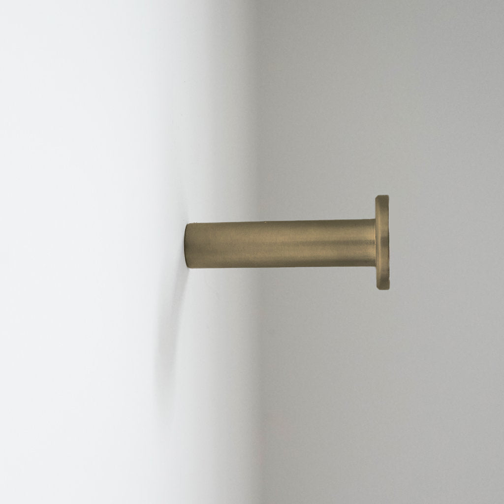 a close up of a CBH Charlie Nail Hook on a white wall.