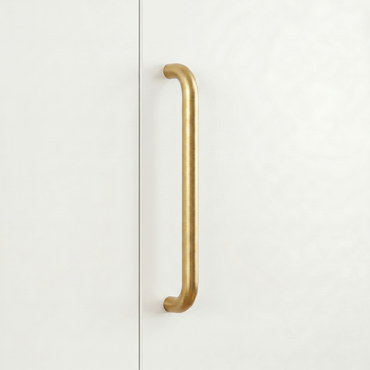 Satin brass Charlie Radius cabinet and appliance pull, a D-shaped tubular handle with radiused corners, mounted vertically on cabinetry.