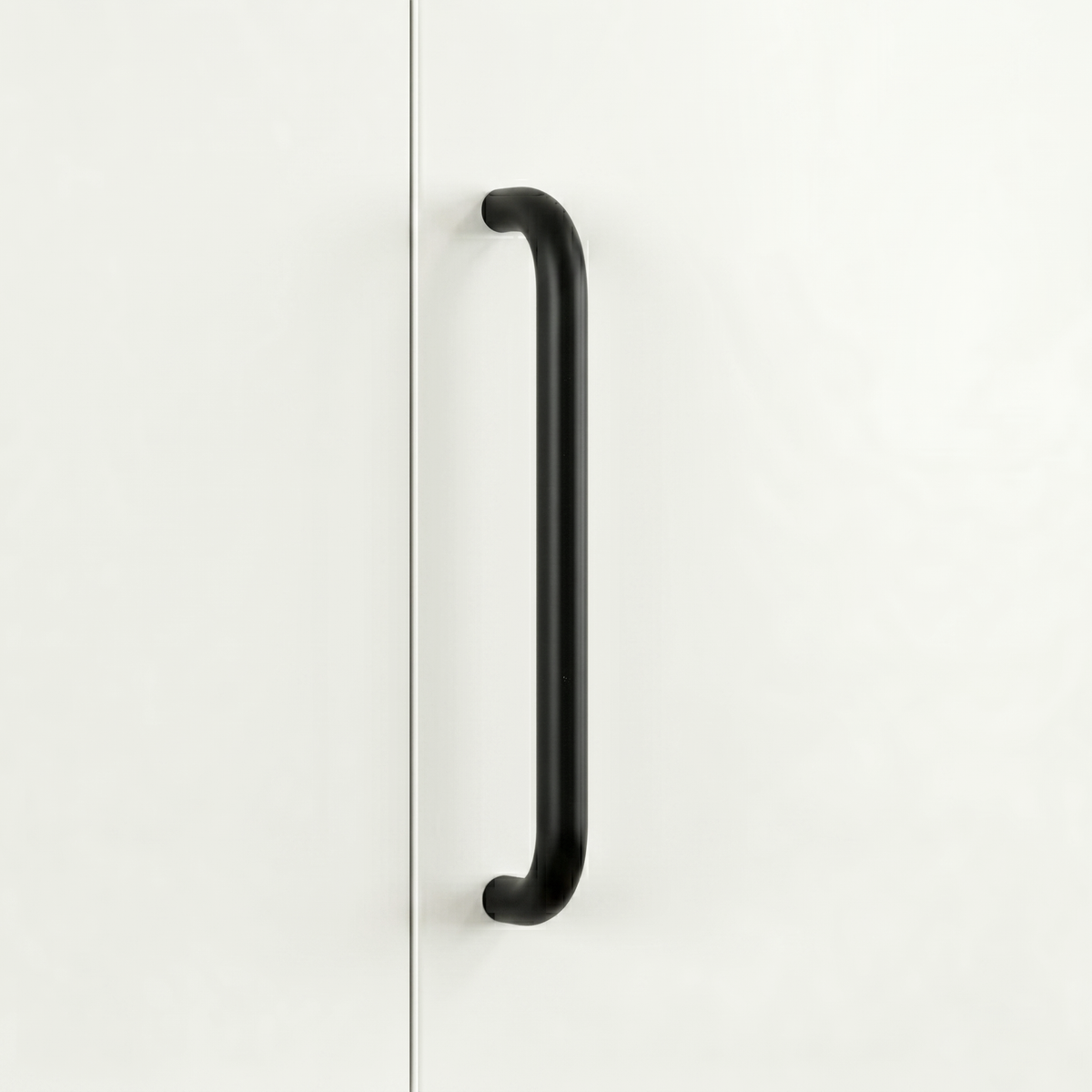 Matte black Charlie Radius cabinet and appliance pull, a D-shaped tubular handle with radiused corners, mounted vertically on cabinetry.