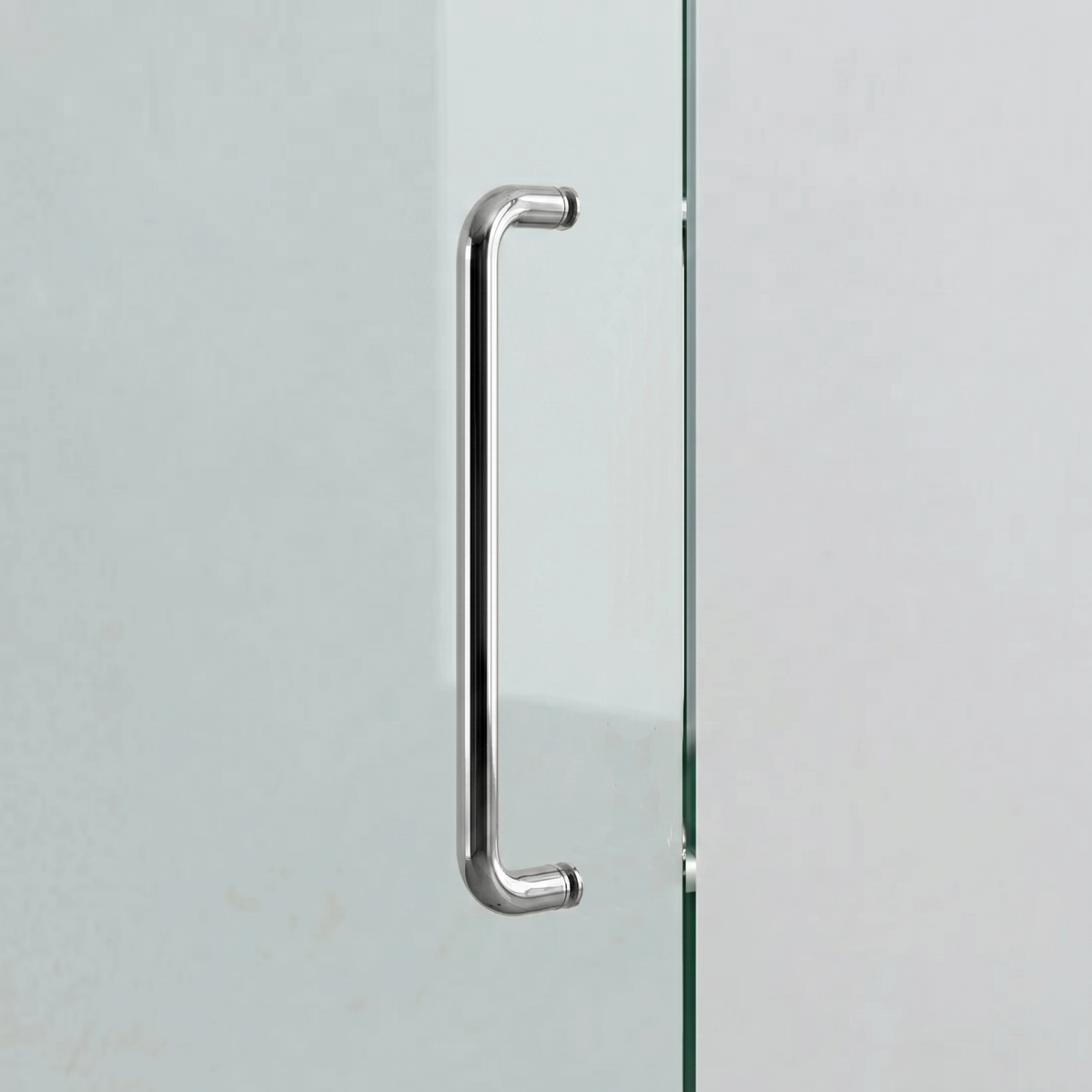 Polished chrome Charlie Radius door pull in a shorter length, D-shaped tubular handle with radiused corners, mounted on a glass door.