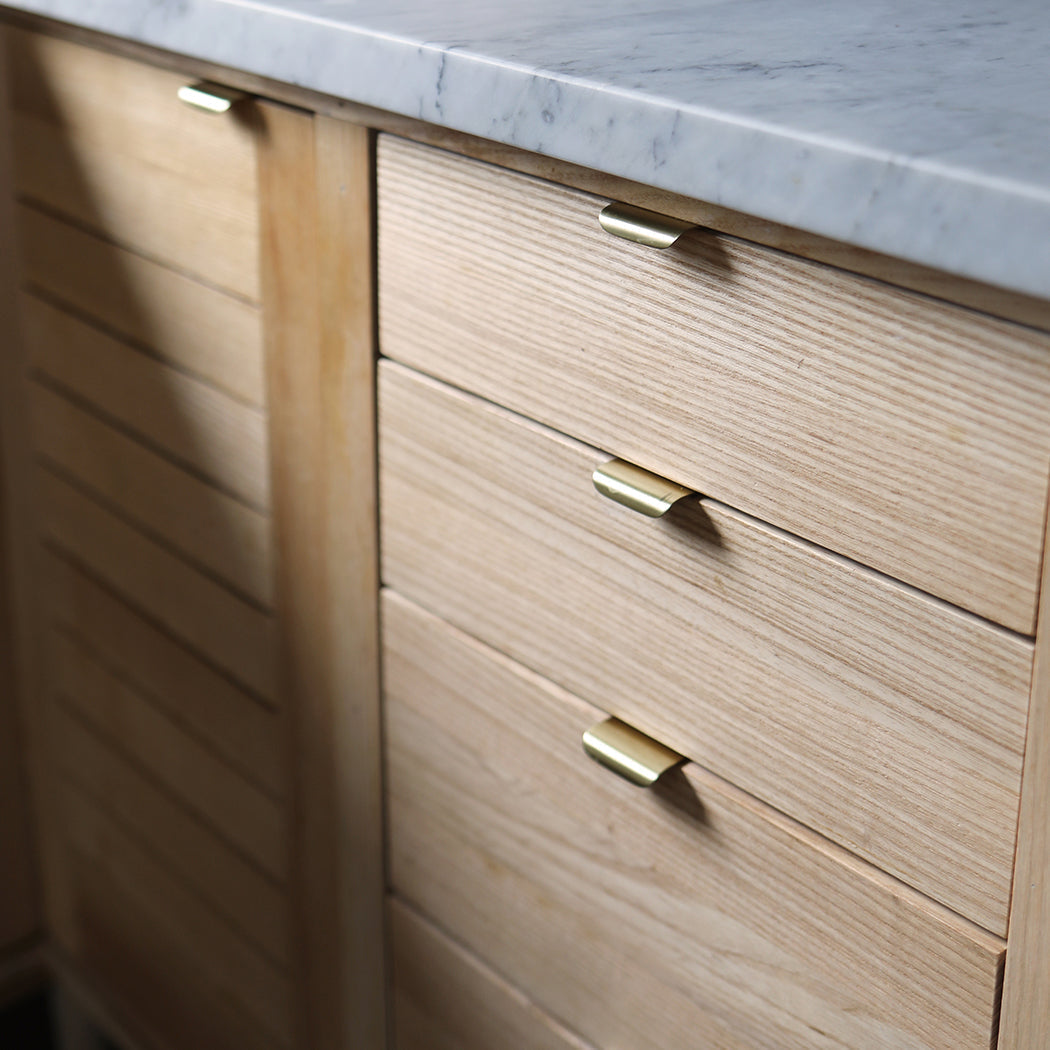 A close up of a CBH Charlie Straight Edge Tab with a wooden cabinet and a marble top.
