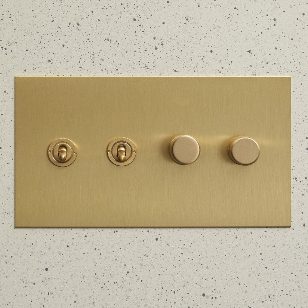 Brass Forbes & Lomax switch plate with two toggles and two rotary dimmers.