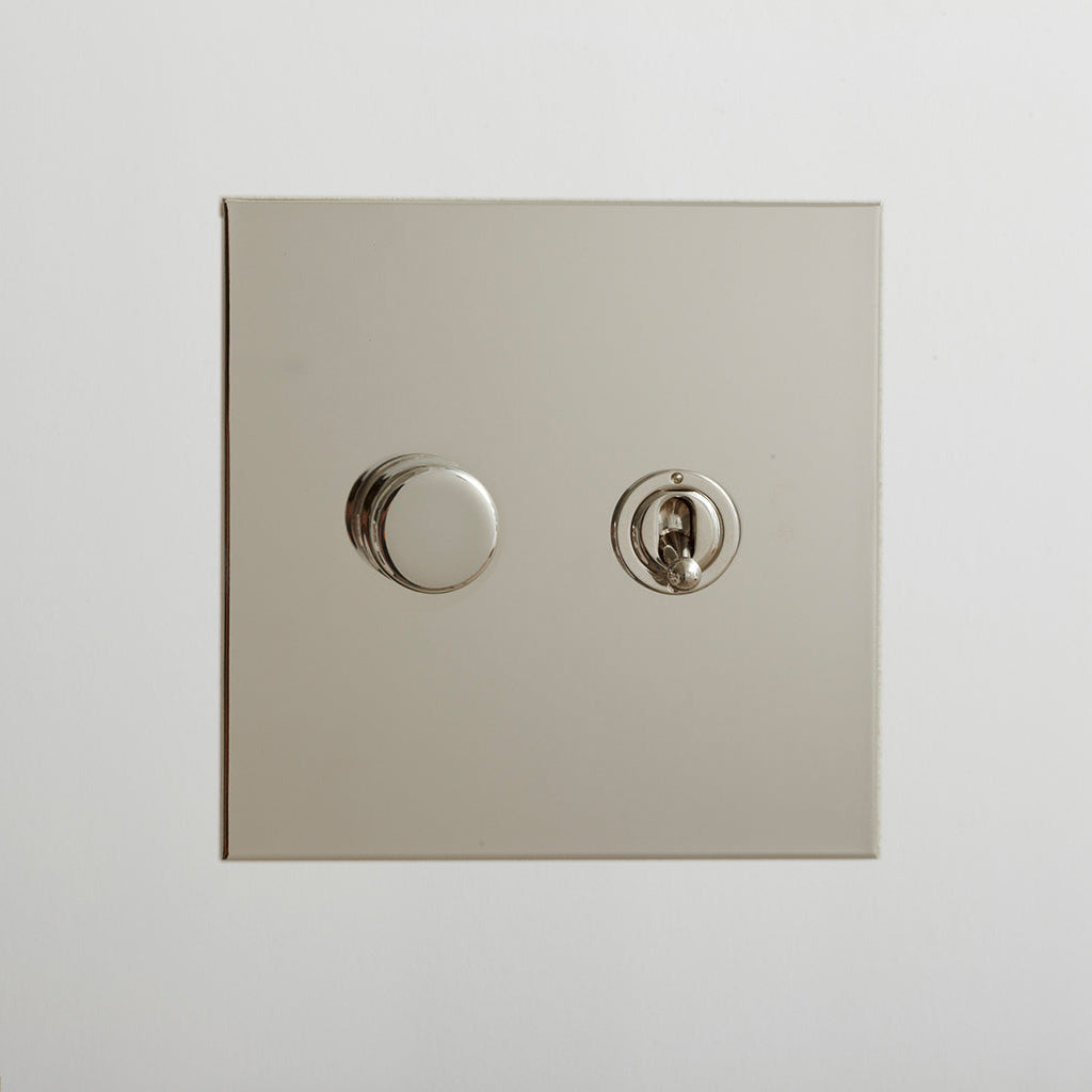 Nickel Forbes & Lomax switch plate with a rotary dimmer and a toggle switch.