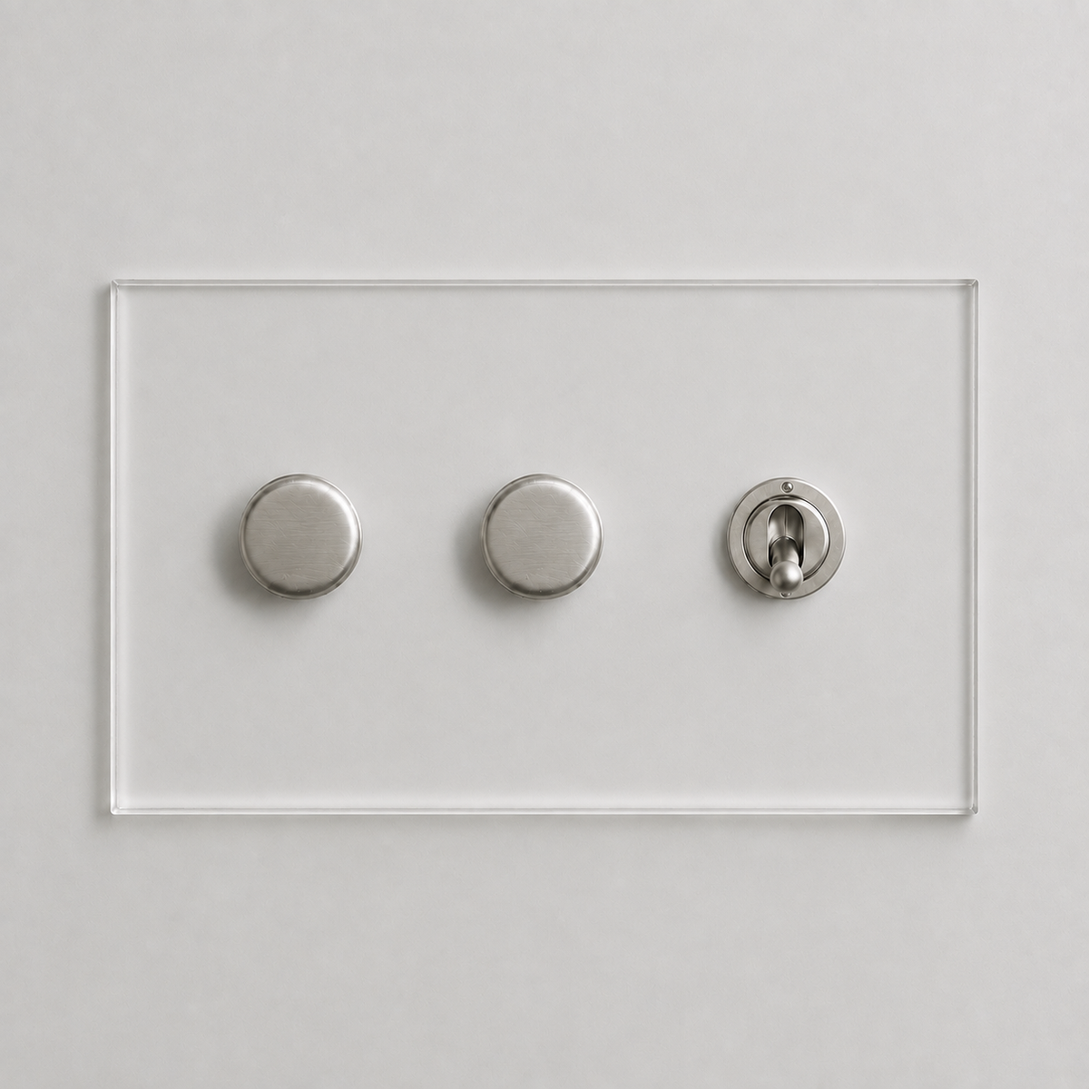 Forbes & Lomax Invisible clear acrylic plate with two brushed metal rotary dimmers and one toggle switch.