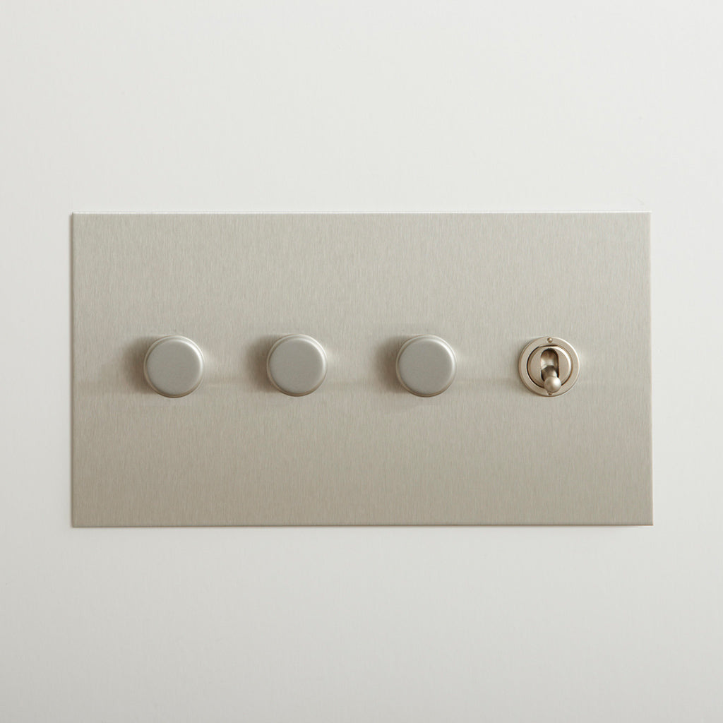 Nickel Forbes & Lomax switch plate with three dimmers and a toggle.