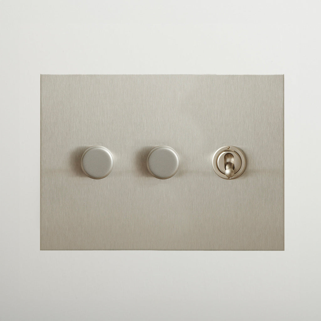 Nickel Forbes & Lomax switch plate with two dimmers and a toggle.