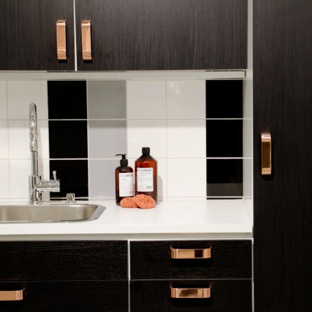 Copper curve handle and knob on modern cabinets.