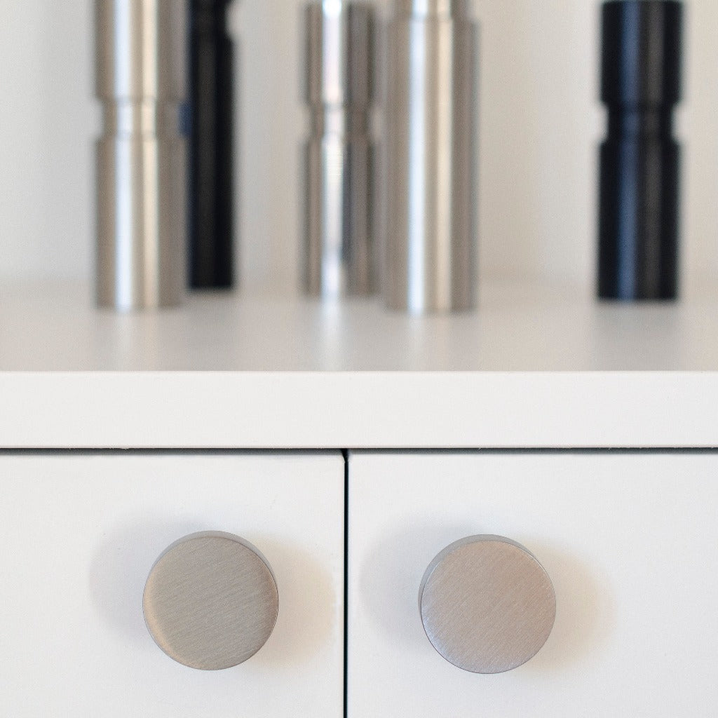 A close up of a white cabinet with Baccman Berglund Dot Knobs.