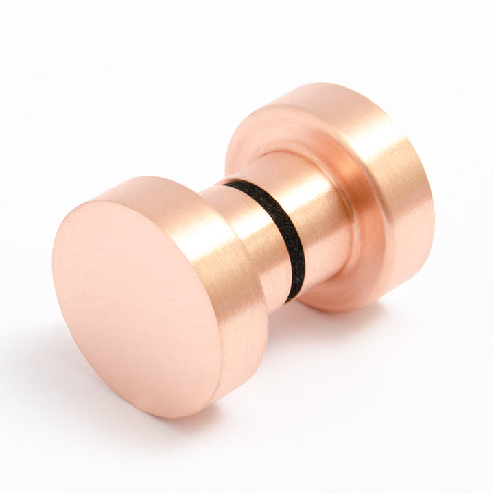 A close up of a Baccman Berglund Dot Shower Door Knob on a white background.