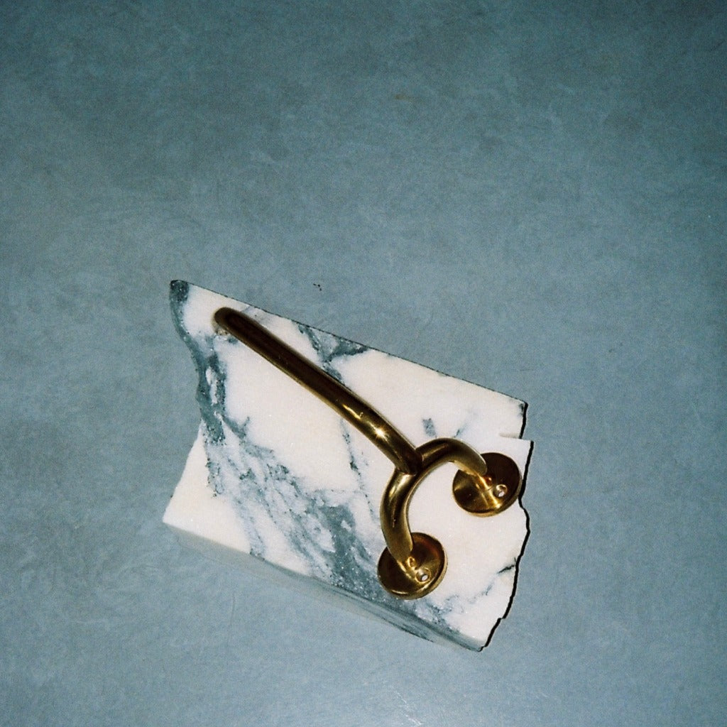Brass Maha Alavi Fauna toilet paper holder on marble.