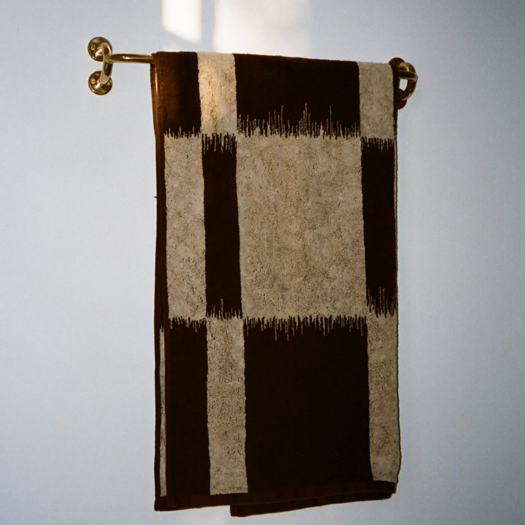Brass Maha Alavi Fauna towel bar with a checkered towel.