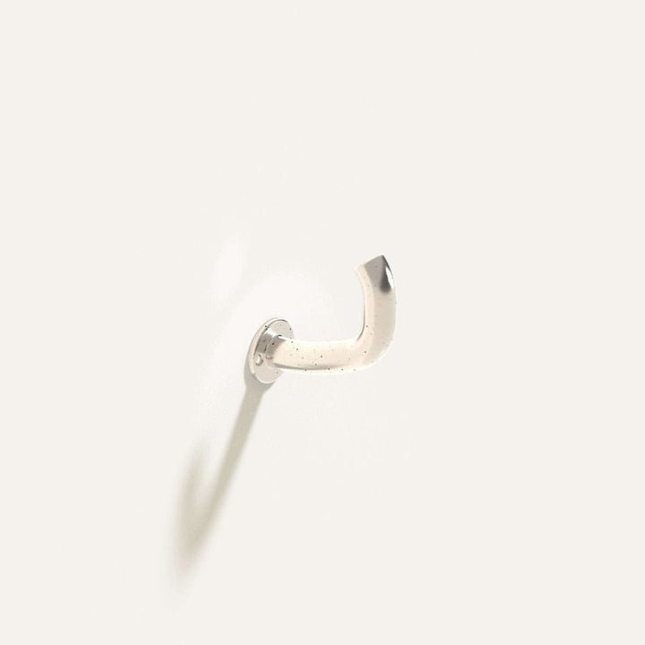 Fauna Wall Hook in polished stainless steel installed on a white wall.