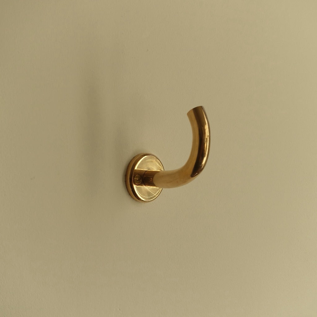 Brass Maha Alavi Fauna wall hook, a curved organic cast hook.