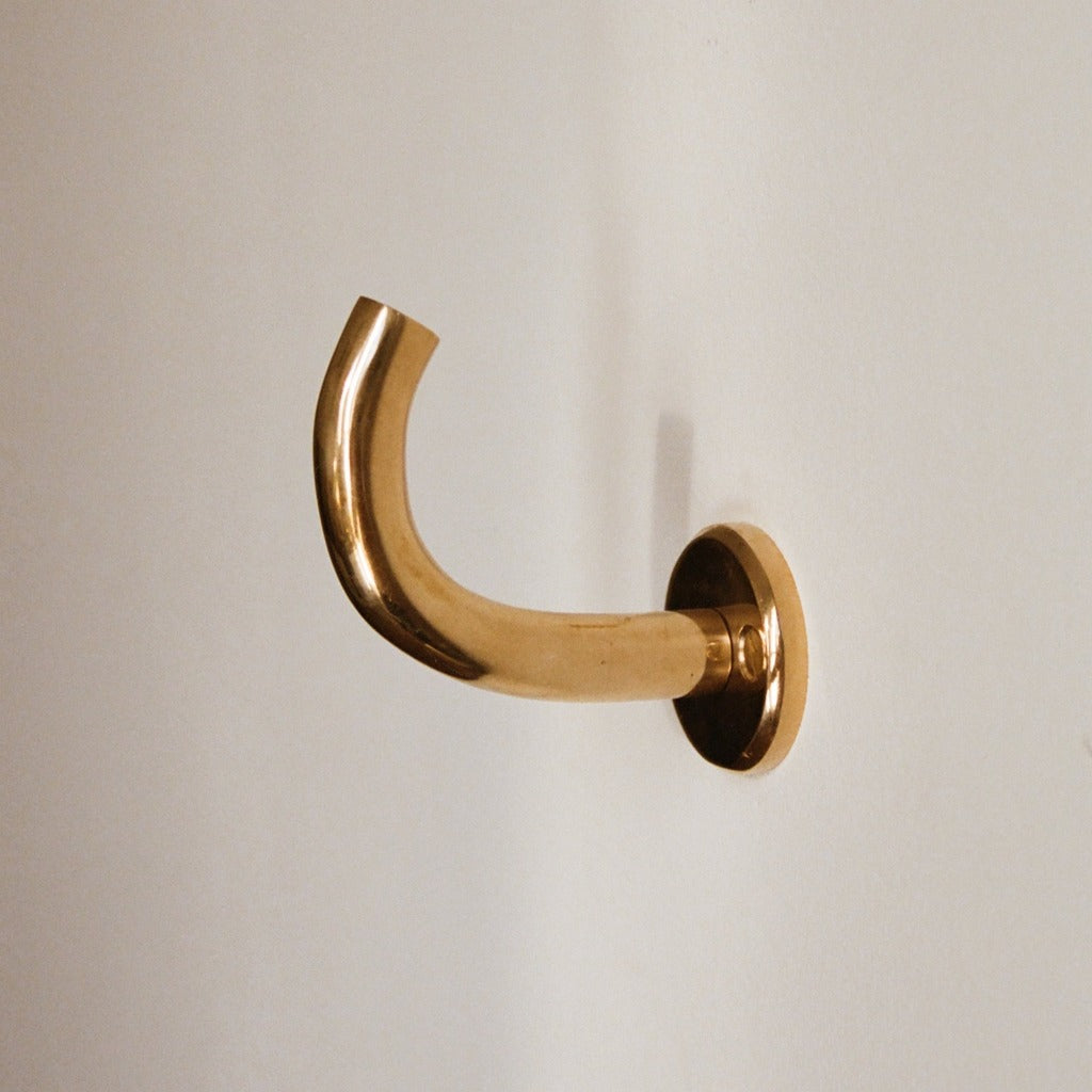Brass Maha Alavi Fauna wall hook, a curved organic cast hook.