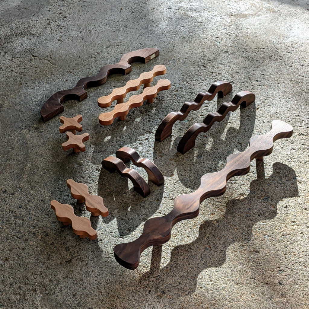 A group of Vivi Lamarre carved wood cabinet pulls in mixed woods.