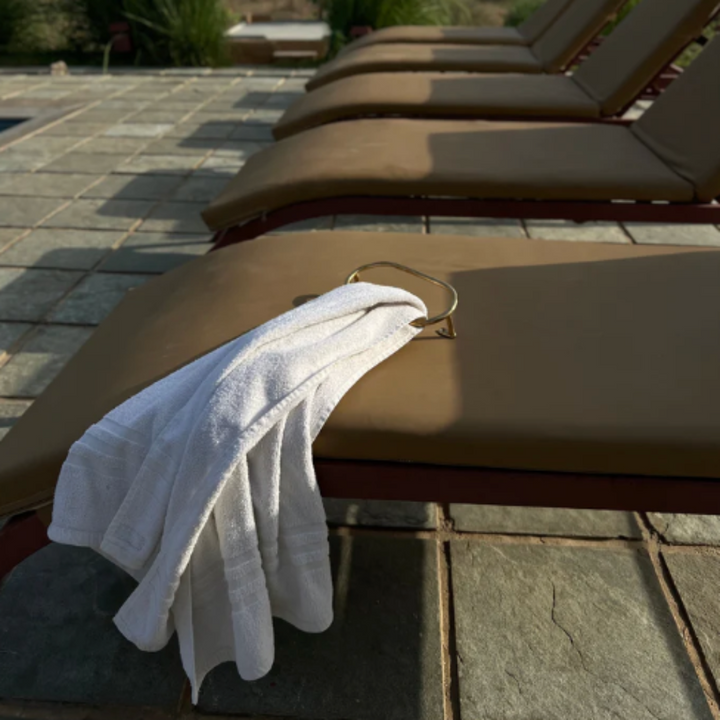 A row of Mi & Gei lounge chairs sitting next to a swimming pool.
