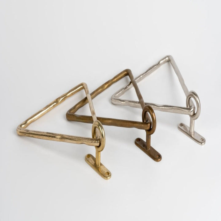 Three Mi & Gei Forme No. 14 Triangle Towel Ring on a white surface.