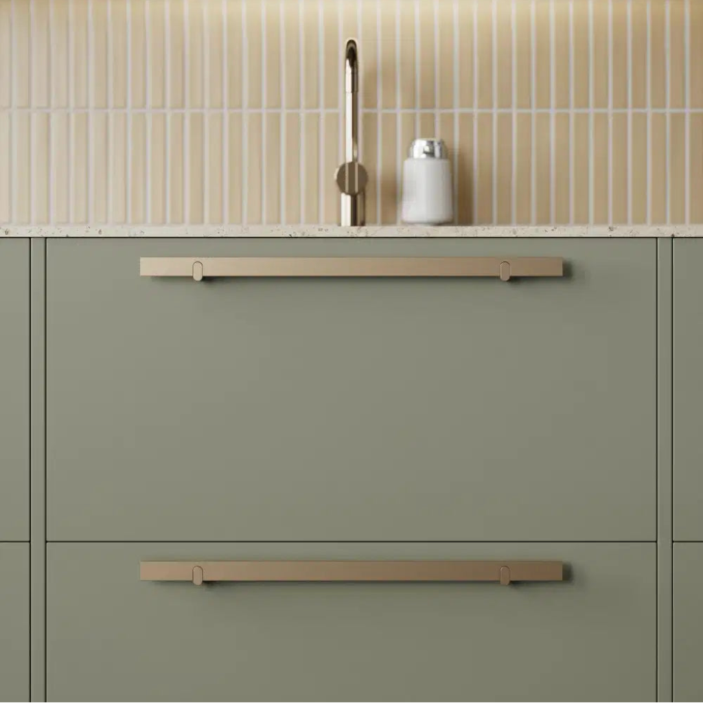 Metal cabinet pull mounted on green drawer